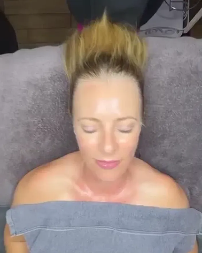 A client resting on Jo's facial bed, her skin dewy and glowing after her facial